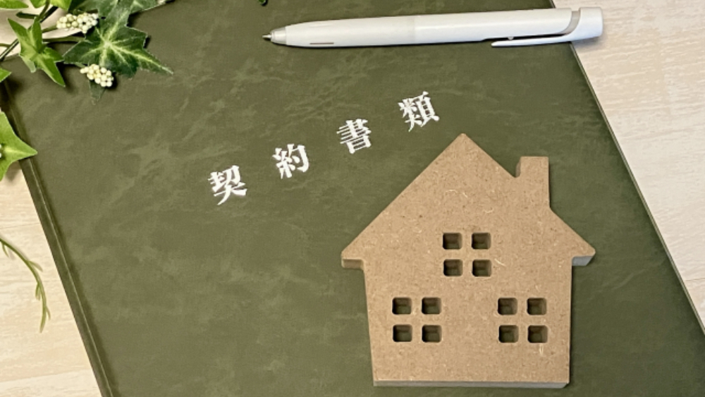 茶色い家のオブジェと契約書類
